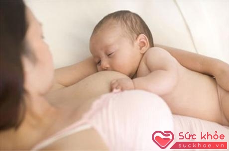 Các bà mẹ có thể nằm ngang cho bé bú để giảm lượng nhiệt tỏa ra và bé sẽ cảm thấy thoải mái hơn khi bú mẹ (Ảnh minh họa).