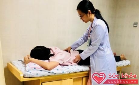 BS đang kiểm tra tình trạng đau lưng cho một bệnh nhân trẻ