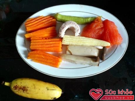 Cà rốt, ngô bao tử, nấm, đậu bắp, thịt heo và cá hồi cùng với món tráng miệng là 1 trái chuối.