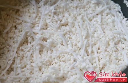 Bước đầu tiên của cách nấu xôi dừa là bạn vo gạo rồi ngâm gạo và trộn cùng dừa nạo.