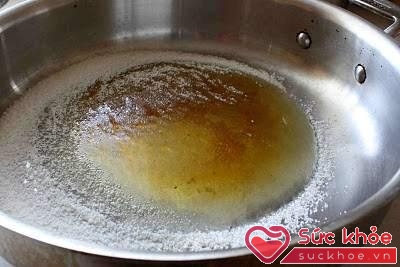 Cho đường vào chảo đun nóng để đường tan hết rồi nhấc xuống đổ nước vào, khi thấy caramel bắt đầu kẹo lại thì bạn lại bắt bếp hâm nóng một lúc