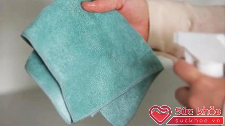 Phun dung dịch tẩy rửa nhẹ lên chiếc khăn sạch.