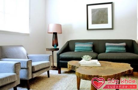 Màu xám của bộ sofa điểm xuyến những chiếc gối xanh lá tạo cảm giác trầm ấm, giản dị của gian phòng khách.
