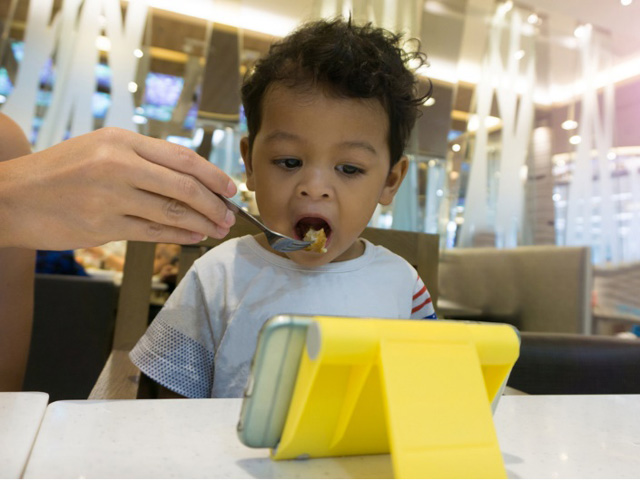 Dỗ con ăn bằng điện thoại chỉ càng làm trẻ biếng ăn hơn
